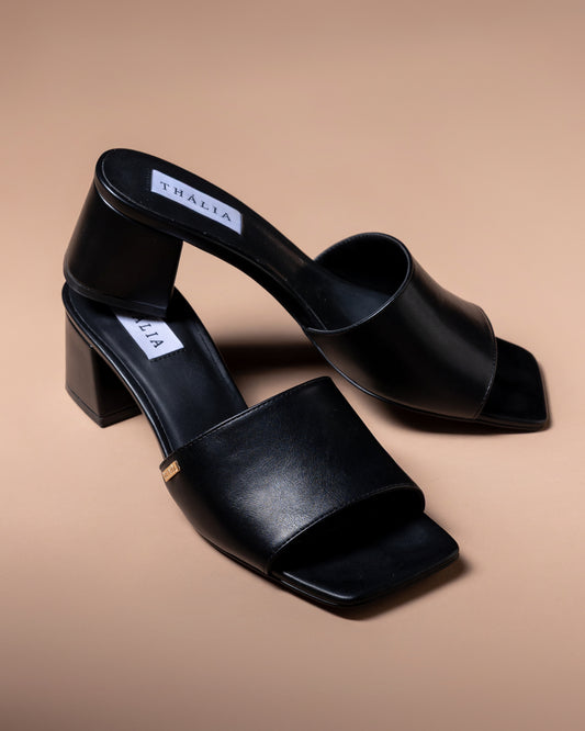 Black open-toe high-heeled shoes on a beige background by Thalia made in vegan leather 